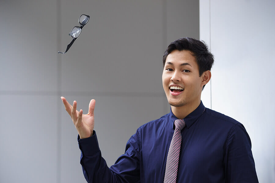 Young man tossing eyeglasses in the air